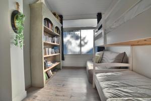 Habitación pequeña con cama y estante para libros en Gite 8 personnes - La Ronçoise, en La Tremblade