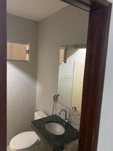 a bathroom with a white toilet and a sink at Pousada Residencial Milagre 01 in Juazeiro do Norte
