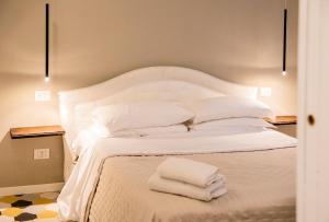 ein Bett mit weißen Kissen und Handtüchern darauf in der Unterkunft Residence Briona in Domodossola