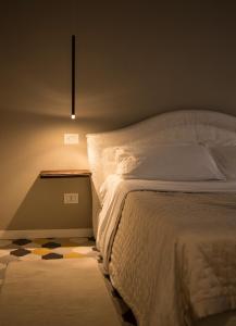 a bedroom with a white bed with a light on it at Residence Briona in Domodossola