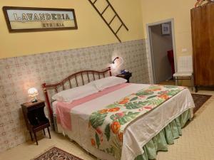 una camera da letto con un letto con copriletto floreale di Démodé a Cortona