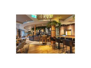 un ristorante con bar, tavoli e sedie di Point A Hotel Dublin Parnell Street a Dublino