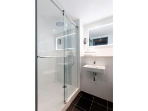 een badkamer met een douche en een wastafel bij Point A Hotel Dublin Parnell Street in Dublin