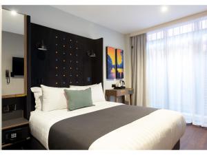 una camera da letto con un letto grande e una grande finestra di Point A Hotel Dublin Parnell Street a Dublino