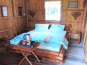 a bedroom with a bed and a table with a tea kettle on it at Mekong Delta Ricefield Lodge in Can Tho