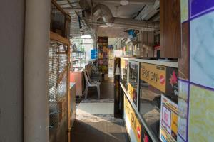 an empty room with a shop with tables and chairs at SPOT ON 90156 Bidara Guest House in Melaka