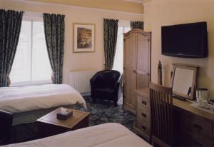 una camera d'albergo con due letti e una televisione di Bank Guest House a Wick