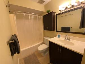 a bathroom with a sink and a toilet and a shower at 1 West in Kahuku