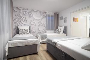 a bedroom with two beds and a wall mural at Apartament w Górach in Nowy Targ