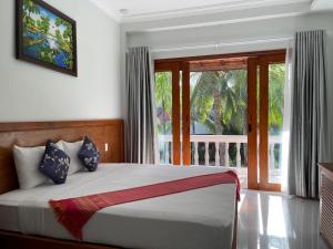 a bedroom with a bed and a large window at Four Oceans Beach Resort - Bon Bien Mui Ne in Mui Ne