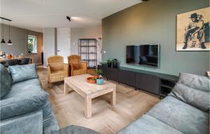 een woonkamer met 2 banken en een flatscreen-tv bij Beautiful Home In Vlagtwedde With House Sea View in Vlagtwedde