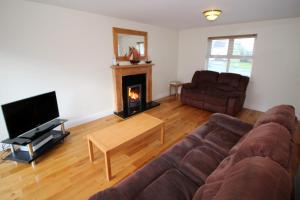 a living room with a couch and a fireplace at SeaSpray Cottage in Rathmullan