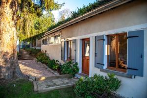 uma casa com portas azuis e uma árvore ao lado em LYONEST chambre d'hôtes em Lyon