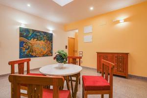 a room with a table and chairs and a painting at AURA HOTEL in Puducherry