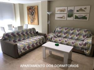 ein Wohnzimmer mit 2 Sofas und einem Tisch in der Unterkunft MARIAGUERRERO - La Casita Azul in Cabo de Palos