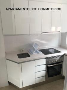 uma cozinha com armários brancos e um lavatório em MARIAGUERRERO - La Casita Azul em Cabo de Palos
