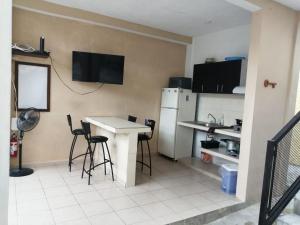 uma cozinha com uma mesa e cadeiras e um frigorífico em Casa de Ana - Habitación privada em Cancún