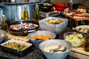 a buffet with many bowls of different types of food at Mona Plaza Zlatibor in Zlatibor
