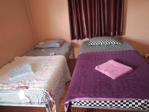 2 camas en una habitación con sábanas moradas en ห้องพัก โฮมทรัพย์ en Ban Thung Pla Kat