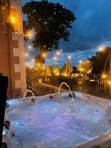 uma banheira de hidromassagem com vista para a cidade à noite em Seawood House Boutique Bed and Breakfast em Lynton