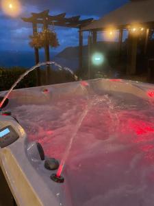 a bath tub filled with red water at night at Seawood House Boutique Bed and Breakfast in Lynton