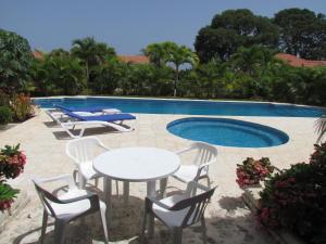 una mesa y sillas junto a una piscina en Villa Sosua Hispaniola Residencial, en Sosúa
