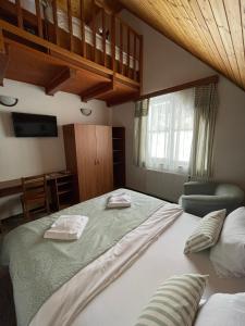 a bedroom with a large bed with two towels on it at Útulna Craft - penzion Veronika in Pec pod Sněžkou