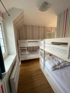 Cette chambre comprend 3 lits superposés. dans l'établissement Balaena - maison avec jardin proche plage, à Luc-sur-Mer