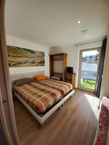 a bedroom with a bed and a large window at Sclap Appartamenti - Livigno in Livigno