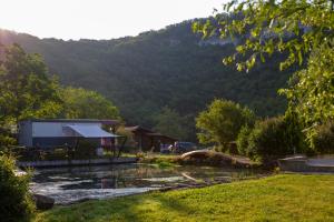 Blick auf ein Haus und einen Fluss mit einem Berg in der Unterkunft pipowagen Blagour gelegen aan waterbron in Lachapelle-Auzac