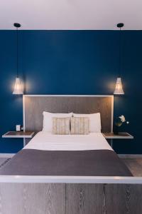 a bedroom with a large bed with a blue wall at Septimo Hostal in Quer&eacute;taro