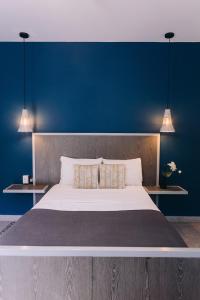 a bedroom with a large bed with a blue wall at Septimo Hostal in Querétaro