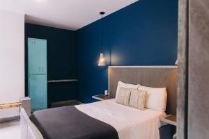 a bedroom with a bed and a blue wall at Septimo Hostal in Quer&eacute;taro