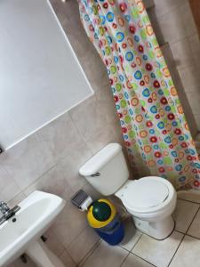La salle de bains est pourvue de toilettes, d'un lavabo et d'un rideau de douche. dans l'établissement Volcano Hostel, à León