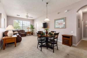 una sala de estar con una mesa y un sofá en The Great Escape - A spacious 1st floor condo on Windsor Palms Resort - close to Disney, en Kissimmee 22 fotos más