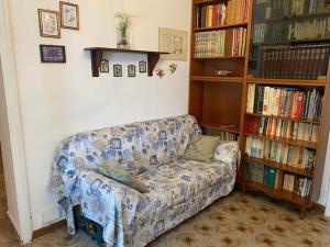 a living room with a couch and a book shelf at Isola d'Elba casa vacanze - Villa Portello - magnetite - la casina in Rio Marina