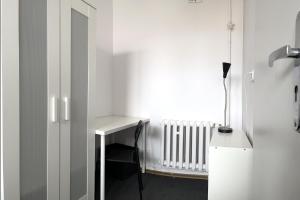 a white room with a desk and a radiator at Stilo Dom - ul Powstańców Śląskich in Wrocław
