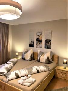Un dormitorio con una cama grande con almohadas. en Ferienwohnungen Sernatinger, en Bad Reichenhall