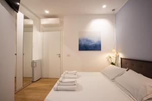 a bedroom with a white bed with towels on it at Bamboo Milano Sinatra Apartment in Milan