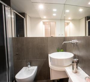 łazienka z białą umywalką i lustrem w obiekcie Bamboo Milano Sinatra w Mediolanie