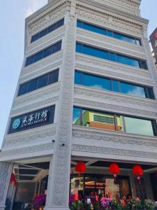 een hoog gebouw met een bord aan de zijkant bij Cai Mei Hotel in Dahu