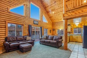 a living room with two leather couches and a kitchen at Worthen Cabin in Garden City