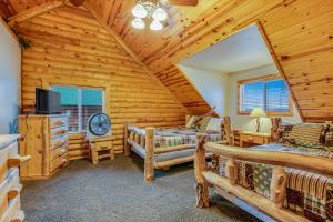 a log cabin bedroom with two beds and a tv at Worthen Cabin in Garden City