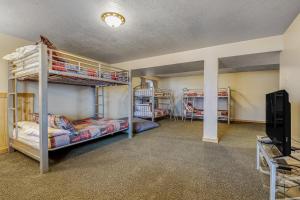 a room with bunk beds and a flat screen tv at Worthen Cabin in Garden City