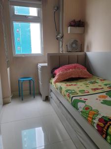 a small bedroom with a bed and a window at Properti9 at Apartemen Green Pramuka in Jakarta