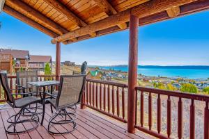 a deck with chairs and a table and a view of the water at Worthen Cabin in Garden City