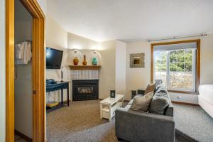 sala de estar con sofá y chimenea en Beaches Inn | Herons Nest Loft, en Cannon Beach
