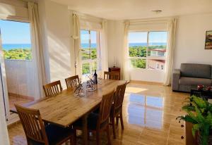 a dining room with a table and chairs and windows at Penthouse with stunning views in Guardamar del Segura
