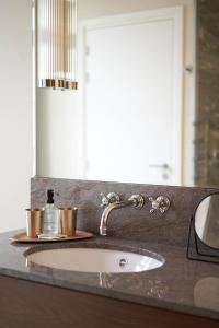 a bathroom counter with a sink and a mirror at Hôtel du Sentier in Paris