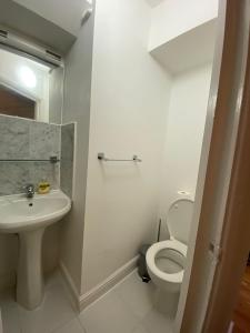 La salle de bains blanche est pourvue de toilettes et d'un lavabo. dans l'établissement F1-Basement Studio Fits 3 Near Paddington, à Londres